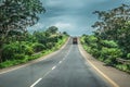 Road view with tropical landscape on two sides, pick up truck, cloudy sky as background