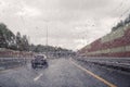 Road view through windshield car window with going rain drops during driving at speed. Unfocused highway. Autumn. Royalty Free Stock Photo