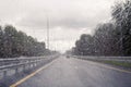 Road view through windshield car window with going rain drops during driving at speed. Unfocused highway. Autumn. Royalty Free Stock Photo