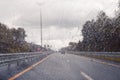 Road view through windshield car window with going rain drops during driving at speed. Unfocused highway. Autumn. Royalty Free Stock Photo