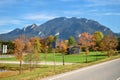 Road in a village with yellow trees on a background of mountains in the Alps Royalty Free Stock Photo