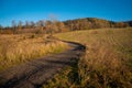 A road winding through fields and meadows. Part of the hiking trail