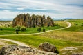 Road winding in green landscape under blue sky with white fluffy Royalty Free Stock Photo