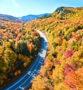 Road winding through New Hampshire mountains in peak fall with stunning foliage