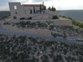 a road winding past a mountain and an old house on top of a hill Royalty Free Stock Photo