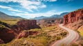 Road winds through canyon with mountains in background under blue sky