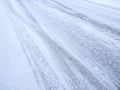 Asphalt covered with snow and imprints of tire tracks