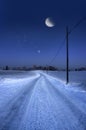 Road in winter evening with moon