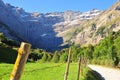 Road with a wooden fence against the background of rocky mountains. Cirque de Gavarnie, France. Royalty Free Stock Photo
