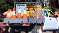 Road work company ute loaded with signs and orange road cones.