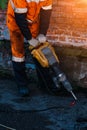 Road worker drilling asphalt on pavement with jackhammer Royalty Free Stock Photo