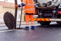 road worker and his truck cleaning the sewers on a road Royalty Free Stock Photo