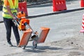 A road worker pulls a petrol drill to cut asphalt concrete samples Royalty Free Stock Photo