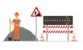 A road worker repairs the road. Fences of the repair site with a detour sign.