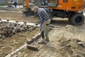 Road worker sweeps sand between cobblestones Royalty Free Stock Photo