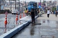 road worker washes asphalt with a hose