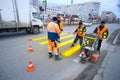 Road workers cause a marking of pedestrian crossing .