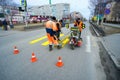 Road workers cause a marking of pedestrian crossing .