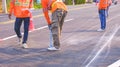 road workers group are marking line for painting traffic color lines on asphalt road with railway track crossing on street surface Royalty Free Stock Photo