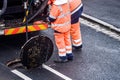 road workers and his truck cleaning the sewers on a road Royalty Free Stock Photo