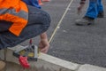 Road workers marking asphalt for painting