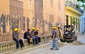 Road workers near the historical painted wall in Havana