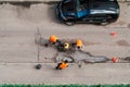Road workers in orange vests repair the road. Pit removal and patching. View from above. works of replacing asphalt parts. Road Royalty Free Stock Photo