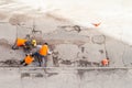 Road workers in orange vests repair the road. Pit removal and patching. View from above. works of replacing asphalt parts