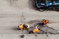 Road workers in orange vests repair the road. Pit removal and patching. View from above. works of replacing asphalt parts Royalty Free Stock Photo