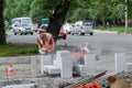 Road workers process and stack a new curbstone on the roadway