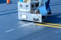 Road workers use hot-melt scribing machines to painting line on asphalt road