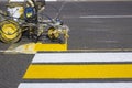 Road workers use hot-melt scribing machines to painting pedestrian crosswalk on asphalt road surface in the city