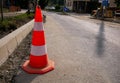 Road works ahead, orange white cone near roadside