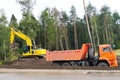 Road works, bulldozer and dump truck widen the road Royalty Free Stock Photo