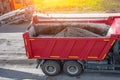 Road works. Dismantling of asphalt pavement. Recycled asphalt crumb is poured over the conveyor belt into the truck body