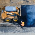 Road works on laying new asphalt with the help of machinery, case excavator and workers, top view - Moscow, Russia, may 21, 2020