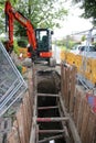 Road works trench with digger at far side Royalty Free Stock Photo