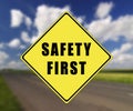 Road with yellow traffic sign safety first text on it Royalty Free Stock Photo