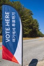 Roadside banner at voting precinct says vote here Royalty Free Stock Photo