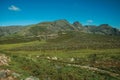 Roadway passing through rocky landscape and green fields Royalty Free Stock Photo