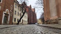 The roadway and sidewalks of the city street are paved with paving stones of different sizes. After a rain, everything is wet. Alo Royalty Free Stock Photo