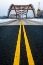 Roadway yellow lane leading to complex modern geometrical bridge