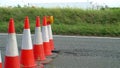 Roadworks cone flashing on UK motorway at evening with traffic passing Royalty Free Stock Photo