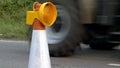 Roadworks cone flashing on UK motorway at evening with traffic passing Royalty Free Stock Photo