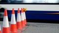 Roadworks cone flashing on UK motorway at evening with traffic passing Royalty Free Stock Photo