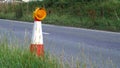 Roadworks cone flashing on UK motorway at evening with traffic passing Royalty Free Stock Photo