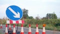 Roadworks cone flashing on UK motorway at evening with traffic passing Royalty Free Stock Photo