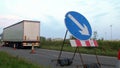 Roadworks cone flashing on UK motorway at evening with traffic passing Royalty Free Stock Photo