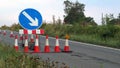 Roadworks cone flashing on UK motorway at evening with traffic passing Royalty Free Stock Photo