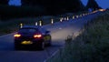 Roadworks cones flashing on UK motorway at night with traffic passing Royalty Free Stock Photo